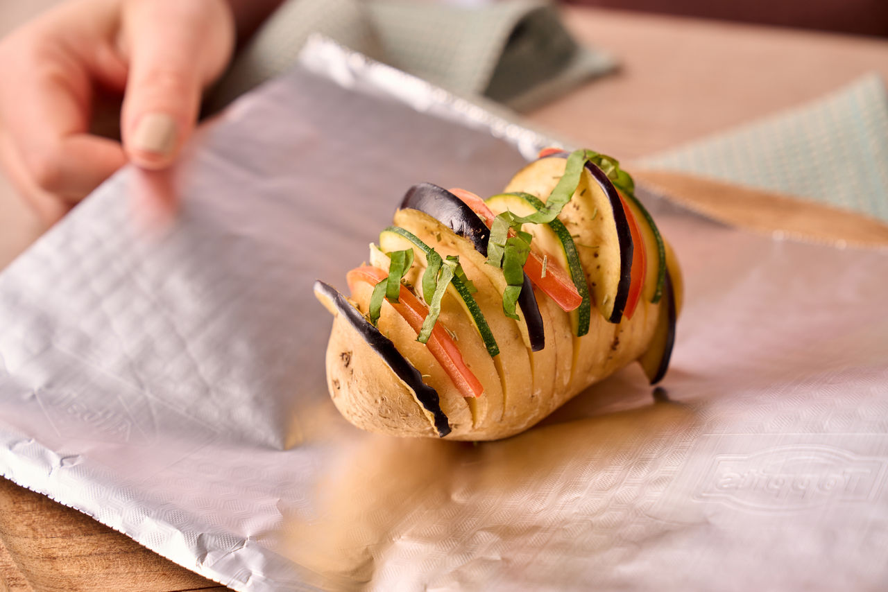 Ofenkartoffel mit Gemüse und Kräutern auf Toppits Alufolie vorbereitet.